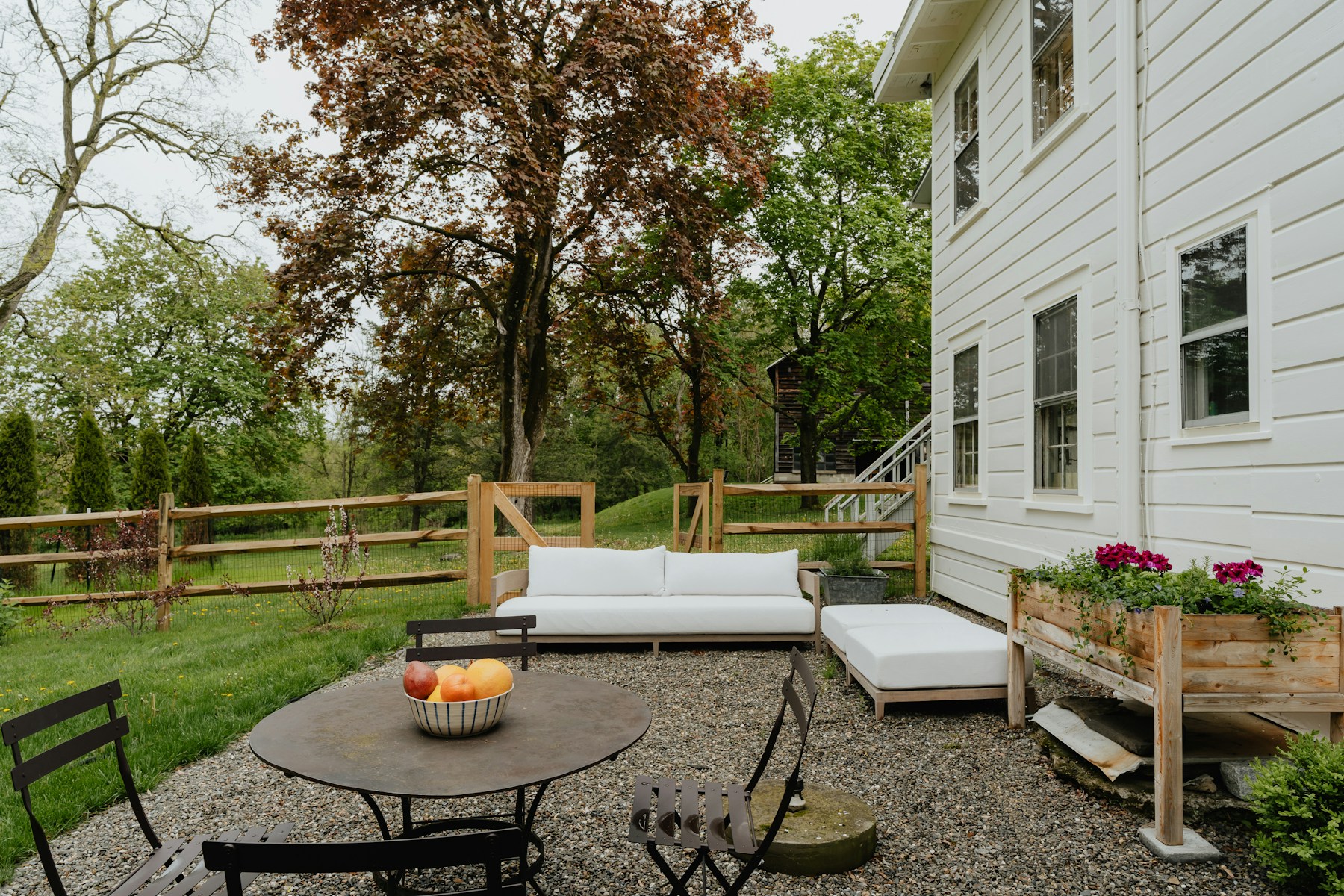 Outdoor sofa and dining set in a bright green backyard